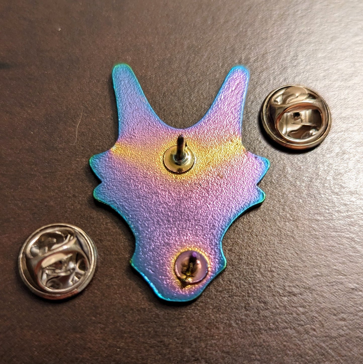 dragon woodshop logo pin in rainbow metal and soft white enamel fill