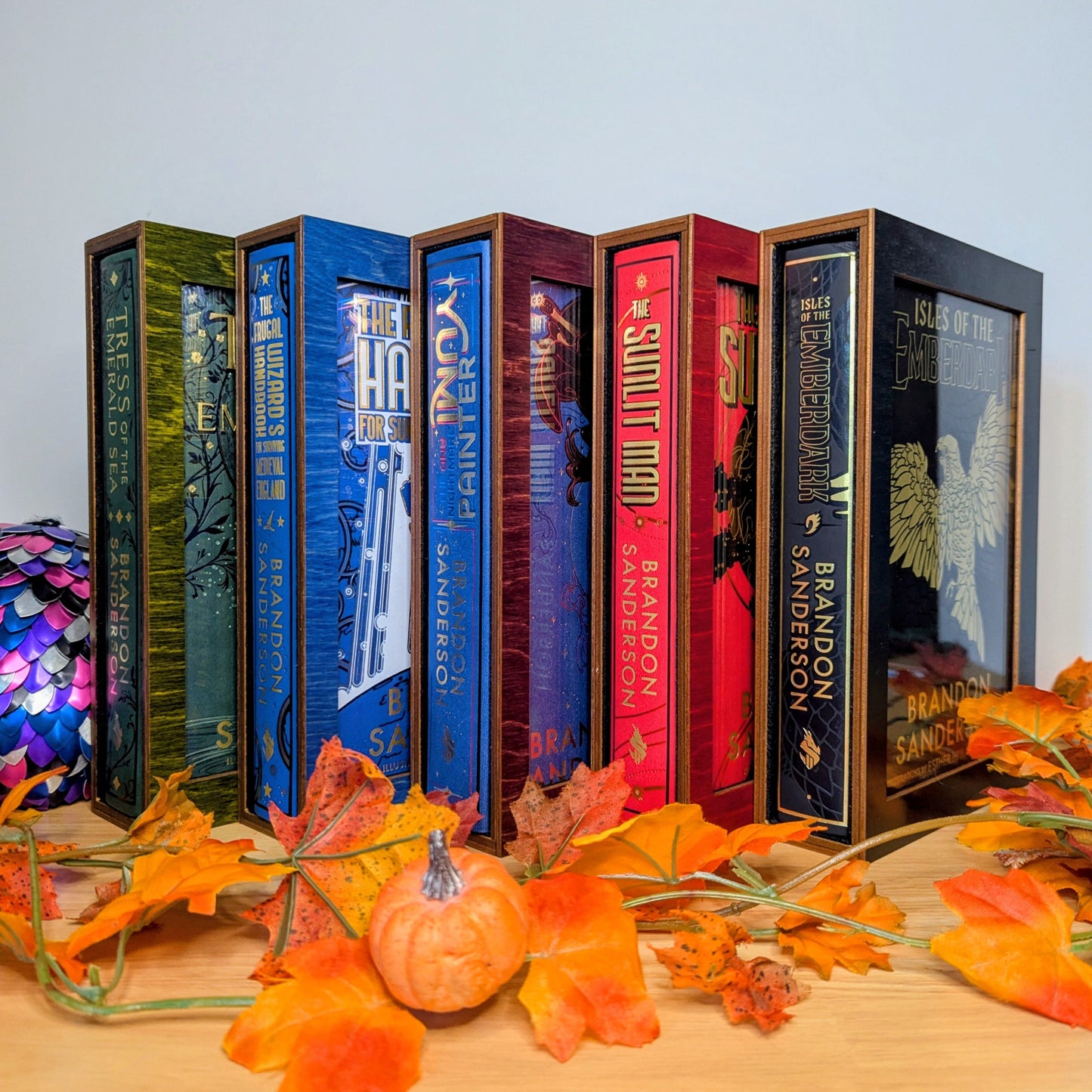 display cases for brandon sanderson's secret project novels, tress, frugal wizard, yumi, and sunlit man