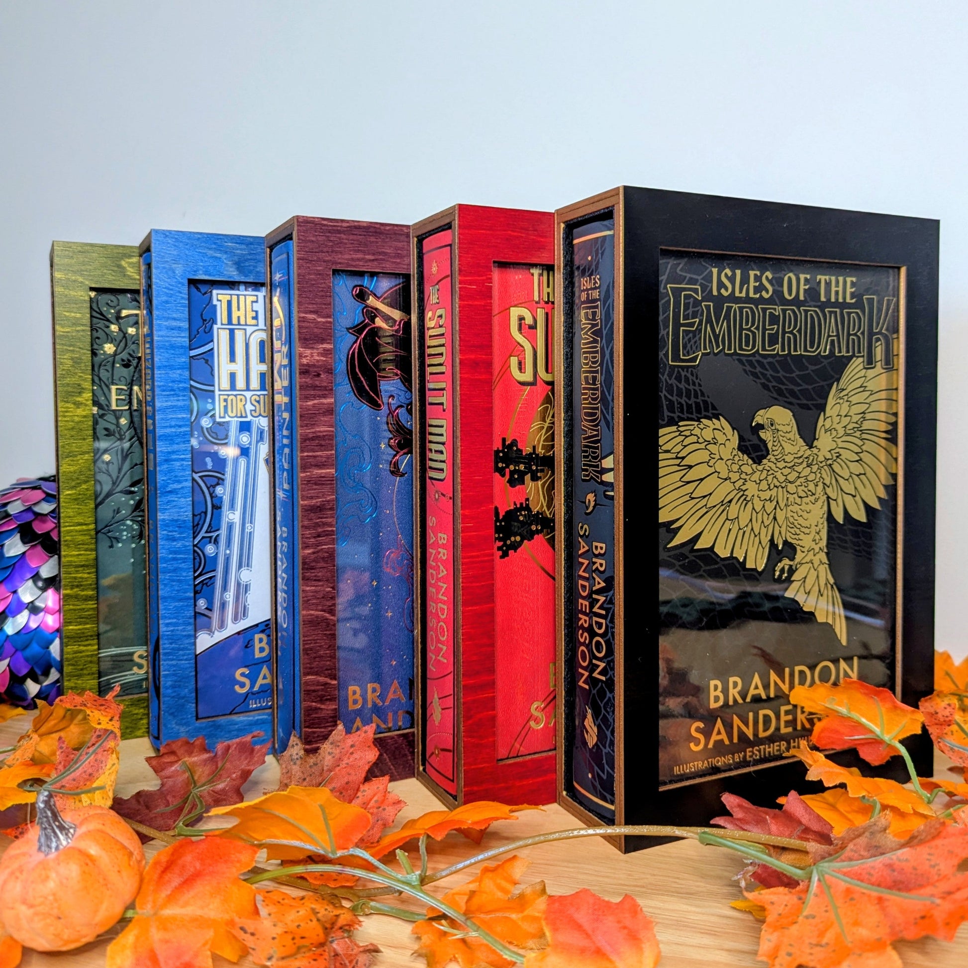 display cases for brandon sanderson's secret project novels, tress, frugal wizard, yumi, and sunlit man